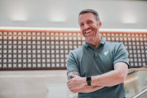 Profissional em ambiente de trabalho com postura aberta e expressão acolhedora