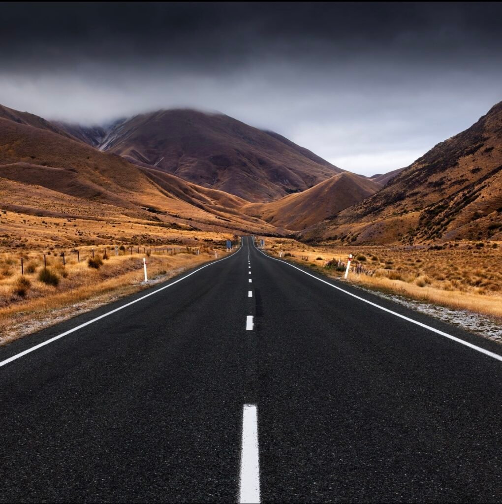 Estrada longa entre montanhas, representando processos que exigem tempo e constância